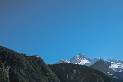 Scenic view of snowcapped mountain against blue sky