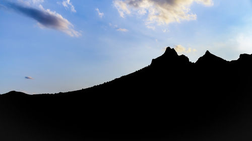 Low angle view of silhouette mountain against sky at sunset