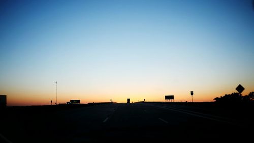 View of road against clear sky at sunset