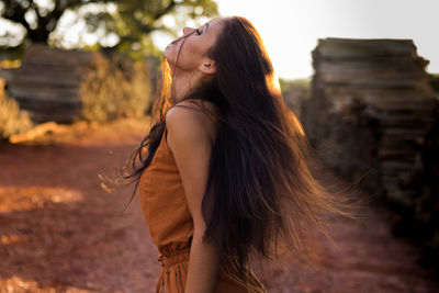 Side view of young woman standing outdoors