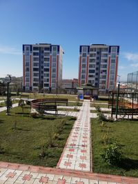 Street amidst buildings against clear blue sky