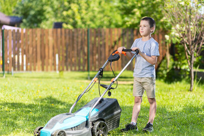 Full length of boy standing by plants