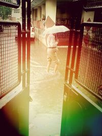 Rear view of woman standing by built structure