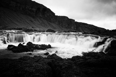 Scenic view of waterfall against sky