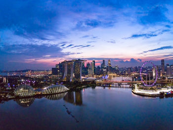 Illuminated buildings in city against sky