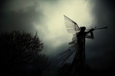 Low angle view of windmill against cloudy sky