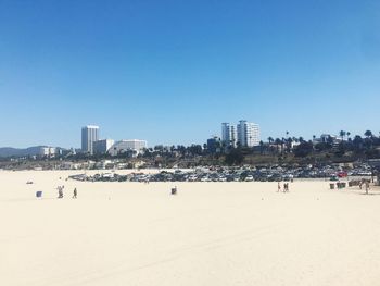 People on beach with city in background