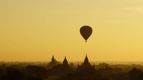 Silhouette of hot air balloons against sky during sunset