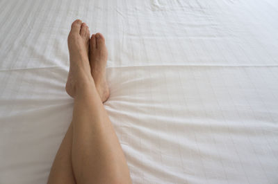 Low section of woman on bed