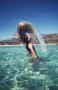 Woman splashing water in swimming pool