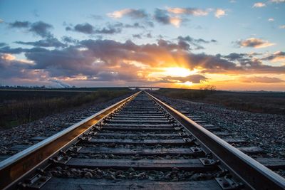 Railway tracks against sky during sunset