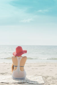 Close-up of hat on beach against sky