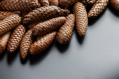 Pile of fir cones on black plastic background