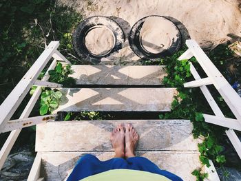 Low section of woman standing on steps at beach