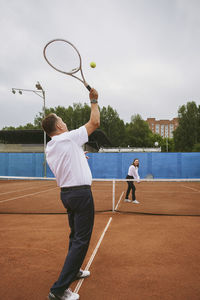 The newlyweds play tennis on the court symbolizing family relations