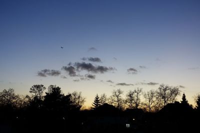 Silhouette birds flying against sky during sunset