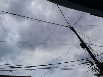 Low angle view of power cables against sky