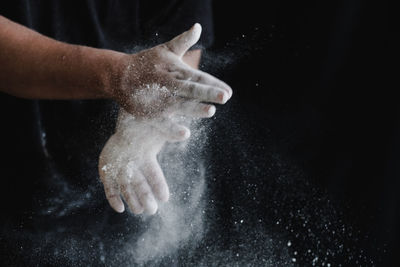 Close-up of hand over black background