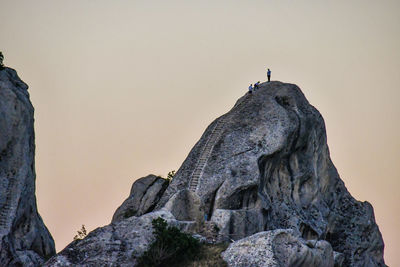 Low angle view of rock formations on mountain against clear sky