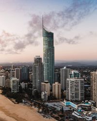 Modern buildings in city against sky during sunset