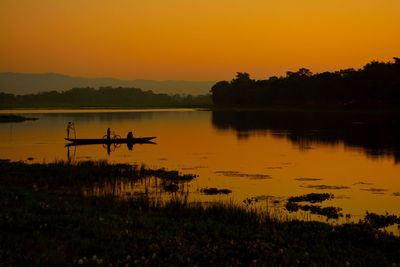 Scenic view of lake against orange sky