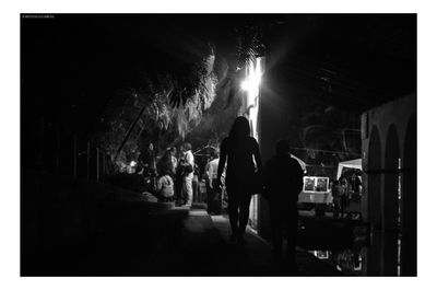 Group of people walking in illuminated building at night