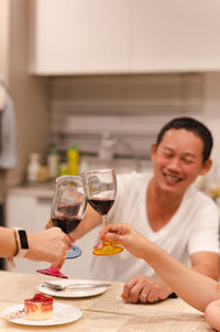 Friends toasting drinks on table