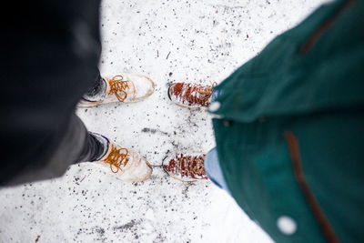 Low section of people standing on snow