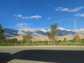 Road by mountains against sky