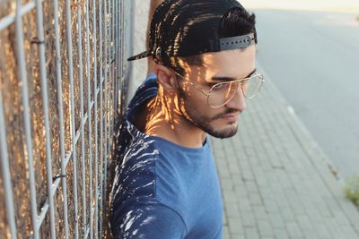 High angle of young man standing by fence