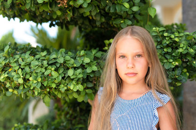 Portrait face of candid happy little kid girl of eight years old with long blond hair and green eyes