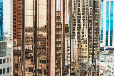 Reflection of buildings on skyscraper in city