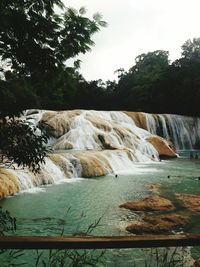 Scenic view of waterfall against sky