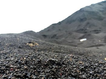 Surface level of dirt road against clear sky