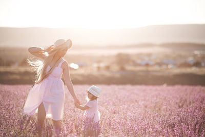 Mother and daughter wearing hat in flowering field