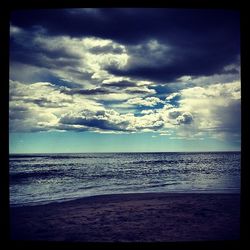 Scenic view of sea against cloudy sky