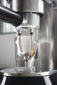 Close-up of pouring coffee in glass at cafe