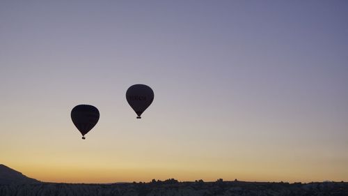 Silhouette hot air balloons against sky during sunset