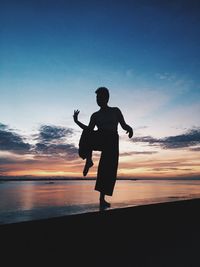 Full length of silhouette dancer dancing by river against sky