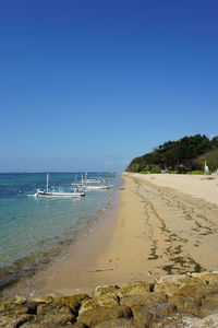 Scenic view of beach against clear blue sky