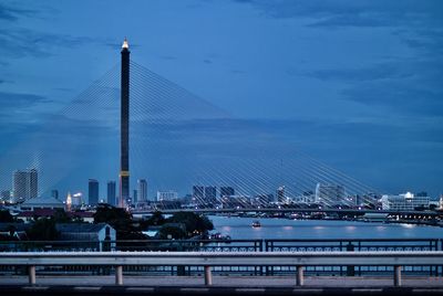 Rama viii bridge over chao phraya river against sky at dusk