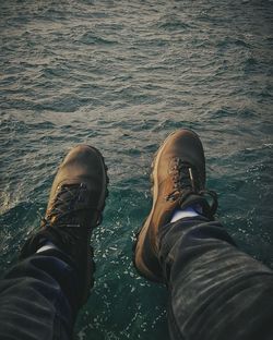 Low section of man standing by sea