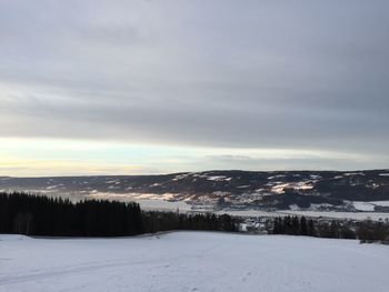 Snow covered landscape against sky