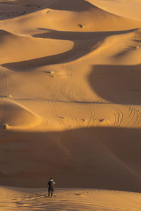 Full length of man on sand dune in desert