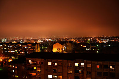 Illuminated cityscape against sky at night