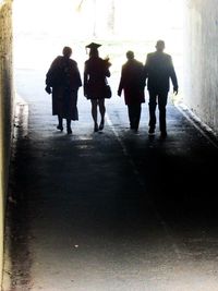 Rear view of silhouette people walking on snow