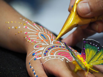 Close-up of person making heena tattoo