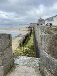 Footpath by sea against sky