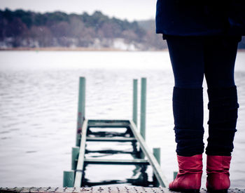 Low section of woman standing in sea