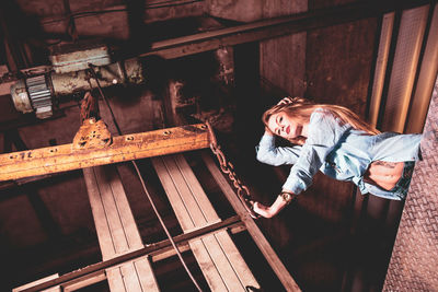 Low angle view of female model posing against metal